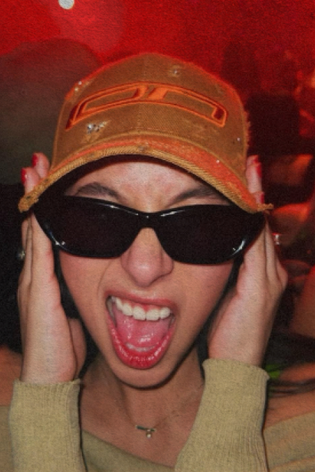 A woman sporting sunglasses and a fashionable hat, immersed in the lively ambiance of a nightclub.